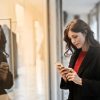 Close-up Photo of Woman in Black Coat Using Smartphone