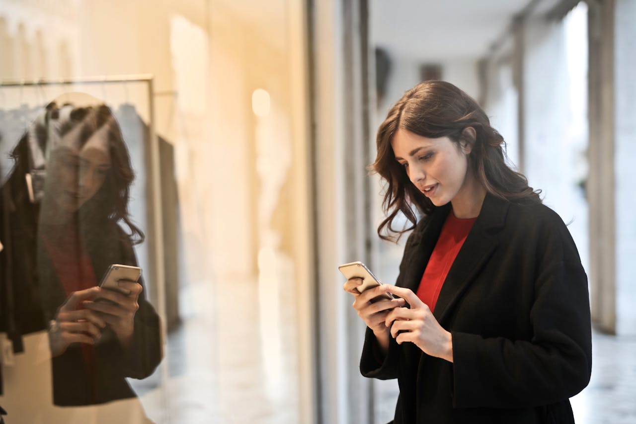 Close-up Photo of Woman in Black Coat Using Smartphone